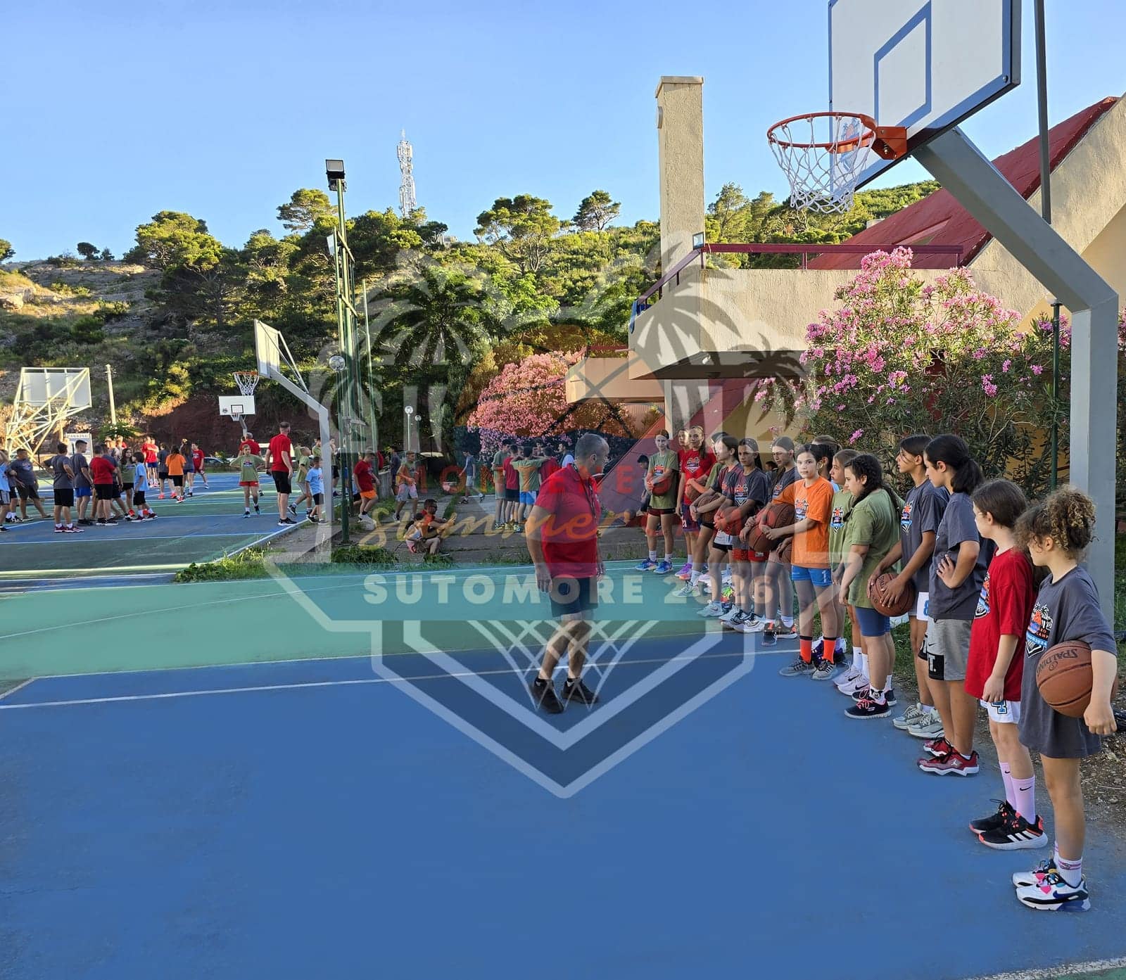 A training session in full swing on the outdoor courts, framed by palms and pines
