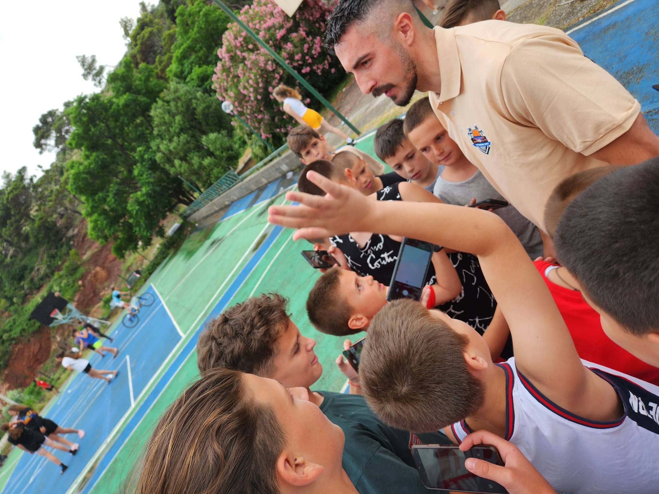A well-known player surrounded by campers photographing him after training